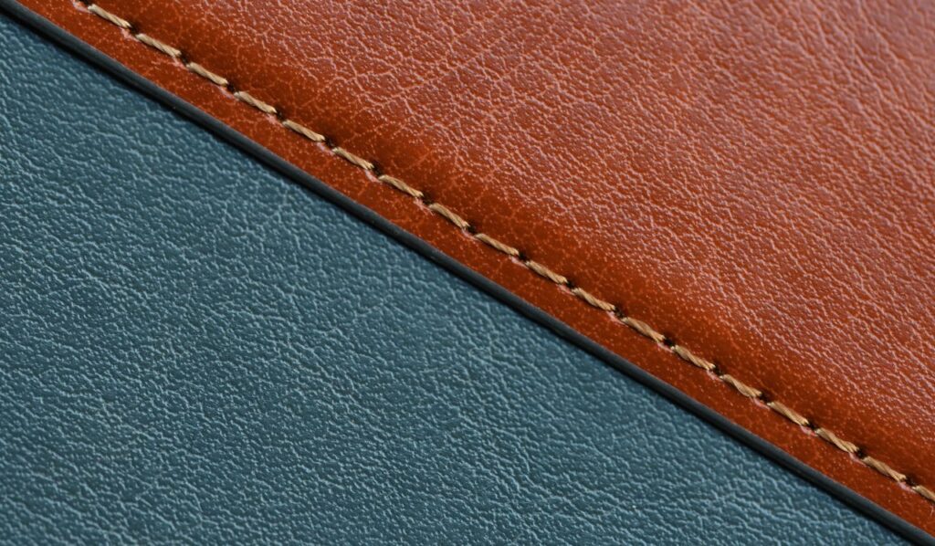 Detailed close-up of brown and blue stitched leather textures, showcasing craftsmanship.