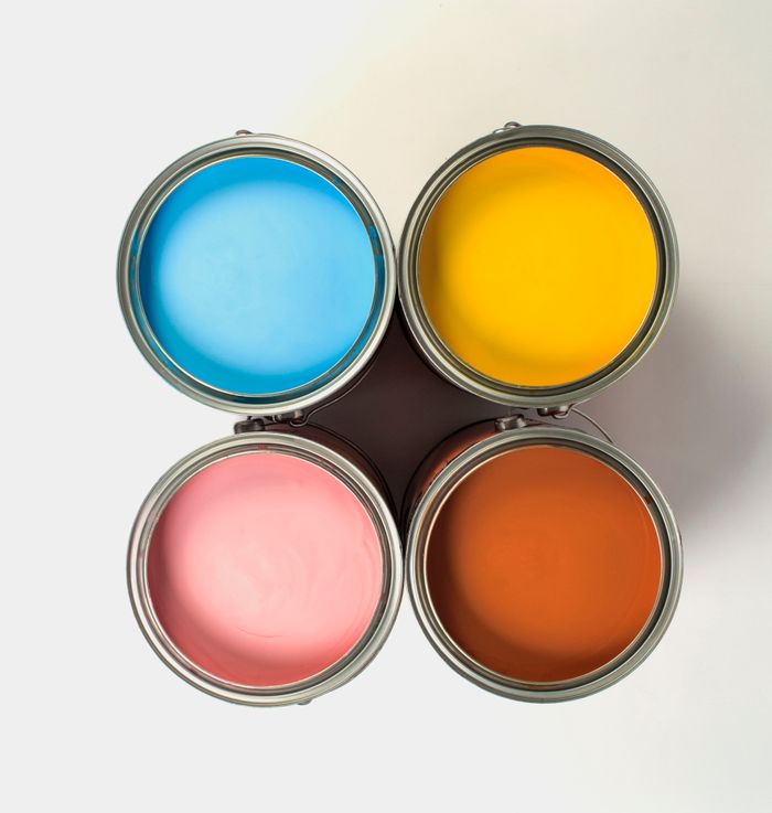 Top view of metal cans with collection of bright paints with smooth surface on white background