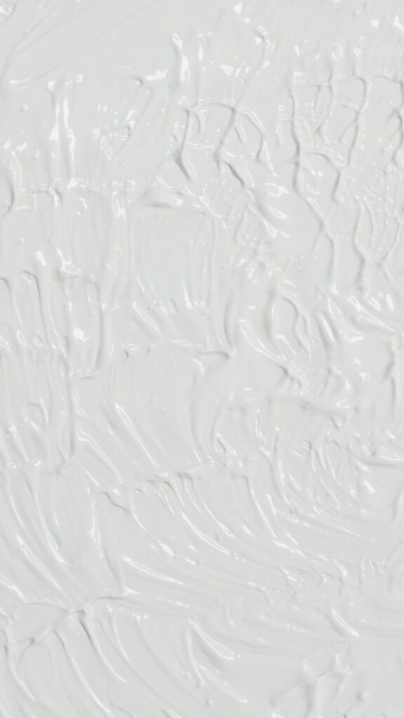 Close-up of abstract white acrylic paint texture with a rough, subtle finish. Ideal for modern art backgrounds.